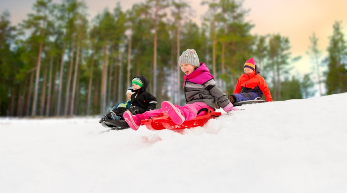 white children sledding in the snow