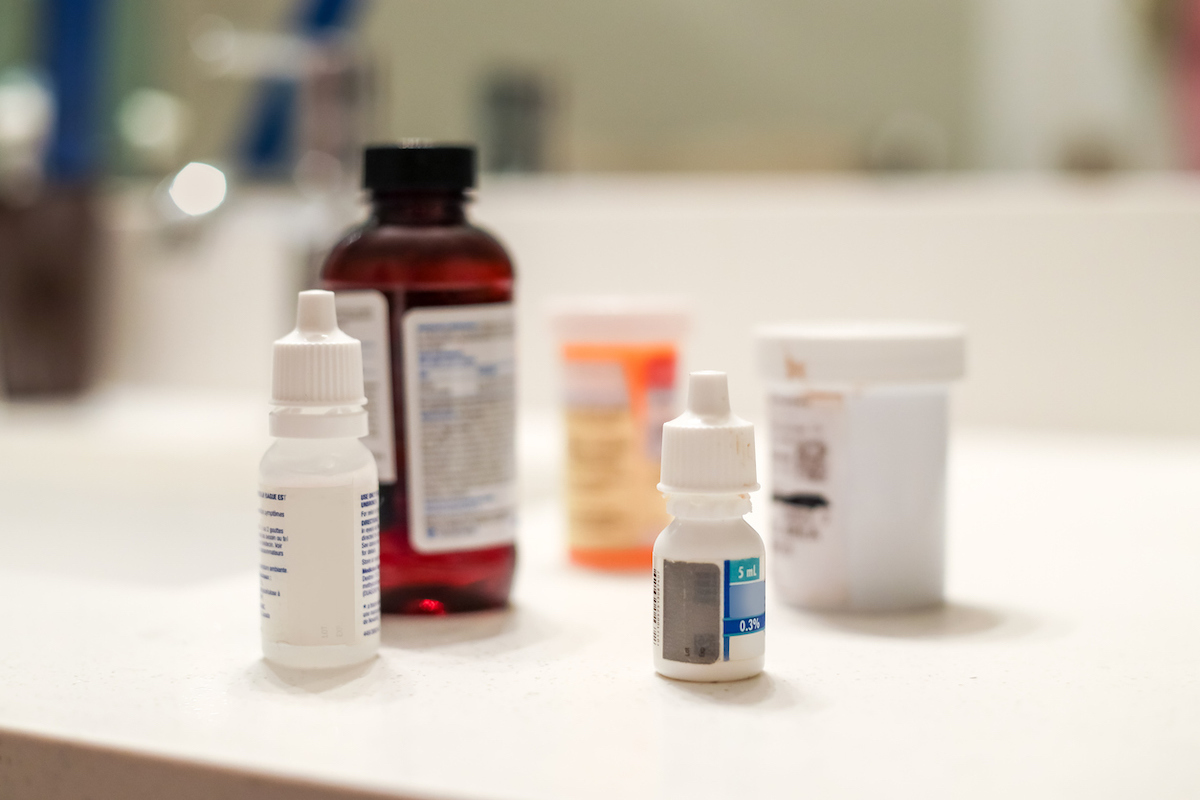 5 Different bottles of medicine sitting on a white bathroom counter