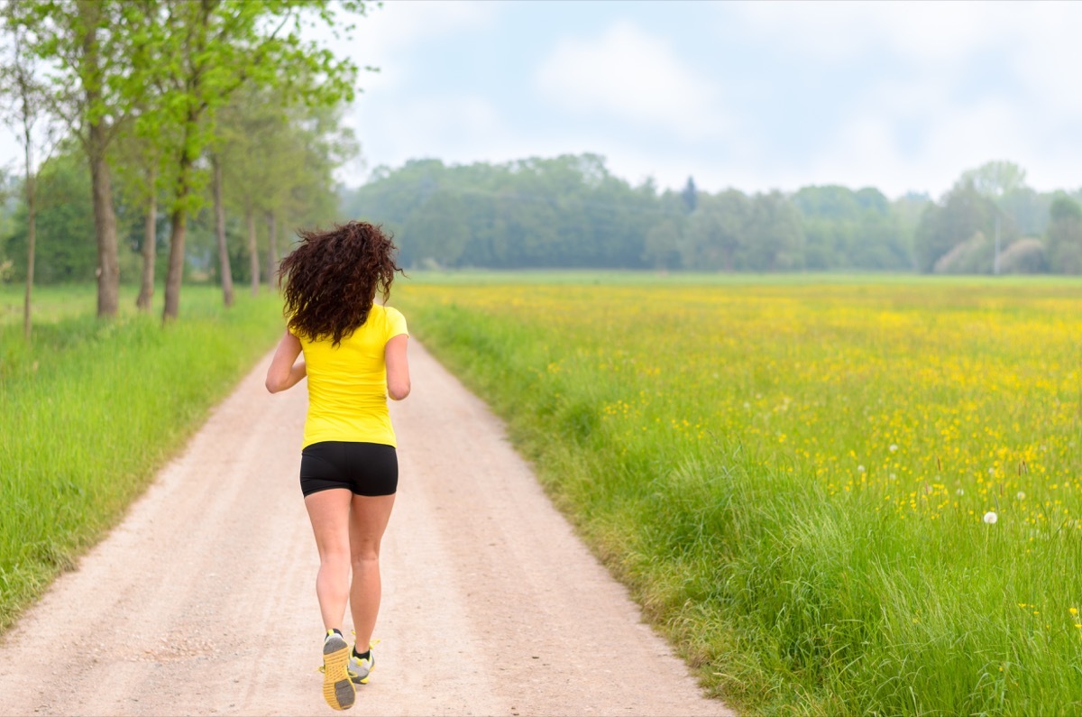 Woman running in a park or farmland area with nobody around town no traffic lights