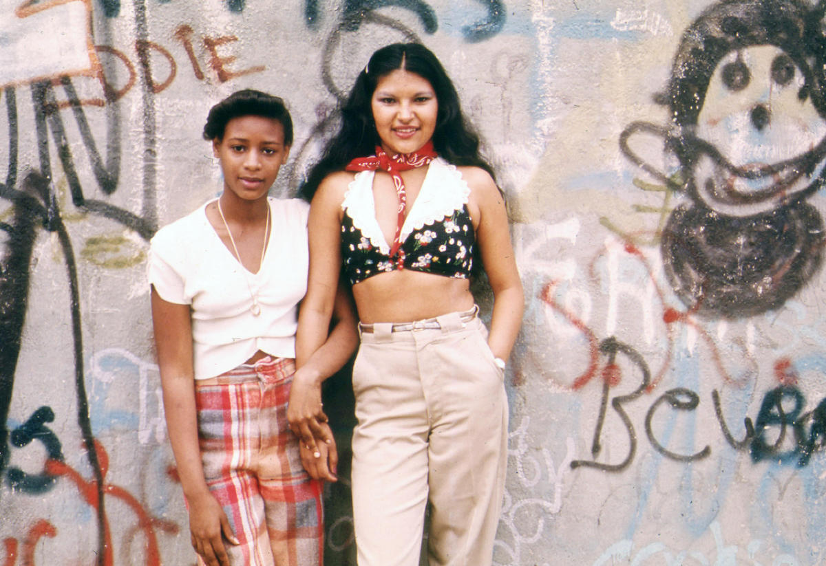 Two teen women Pose in Front of a Wall of Graffiti in Lynch Park in Brooklyn, New York City in June 1974