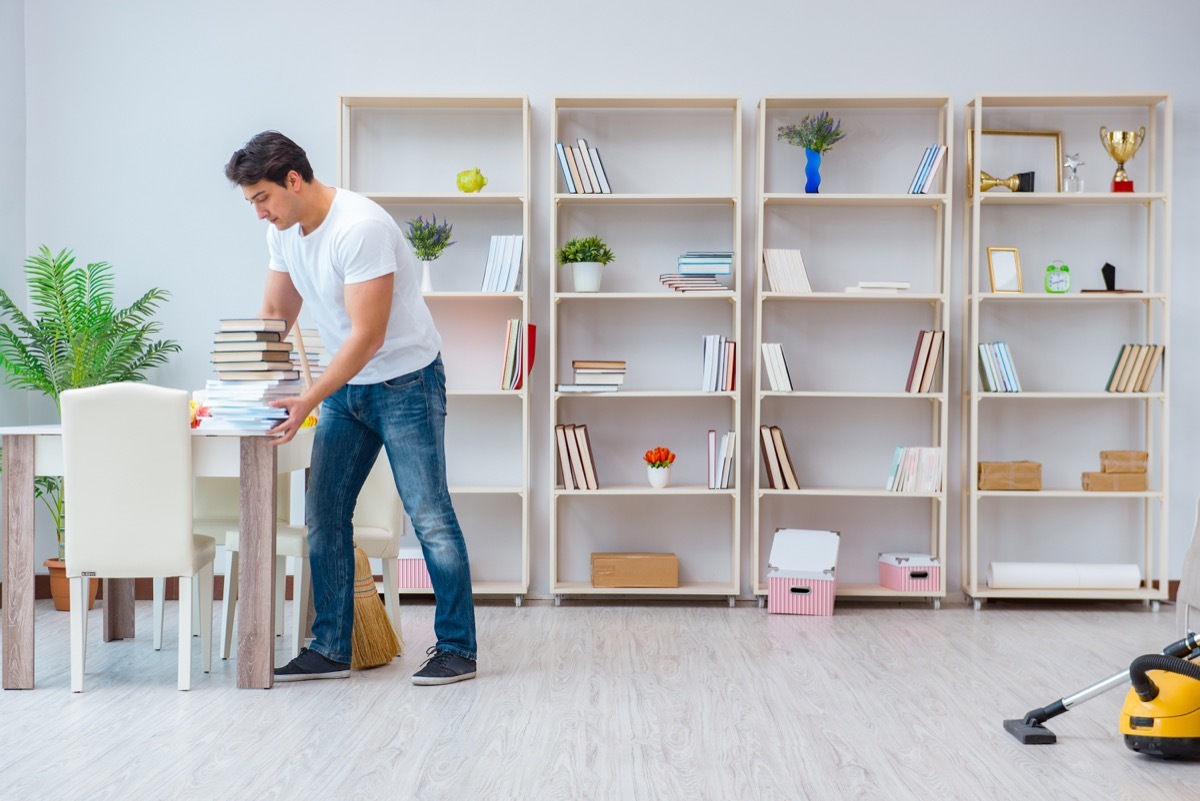 Man organizing his bookcase