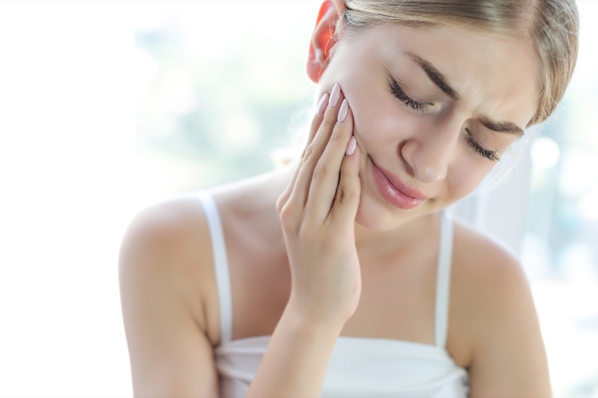 woman rubbing face in pain