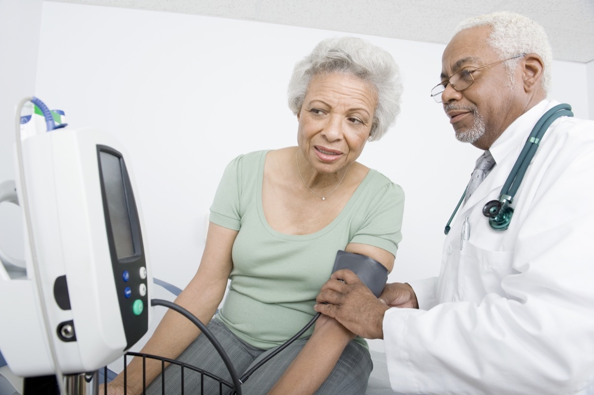 woman and doctor taking her blood pressure looking at the screen, health questions after 50