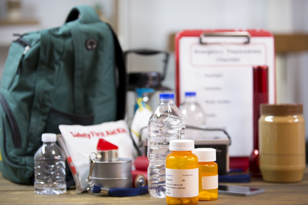 Emergency preparedness supplies. A large collection of supplies to be used in case of a natural disaster (hurricane, flood, earthquake, etc) including flashlight, backpack, batteries, water bottles, first aid kit, lantern, radio, can opener and mask. No People.