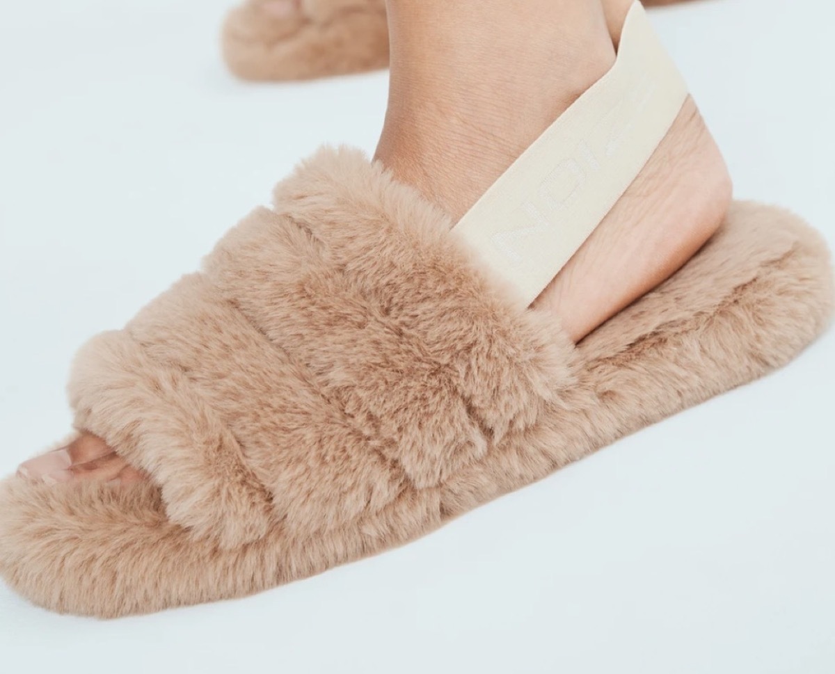 feet in brown faux fur slides