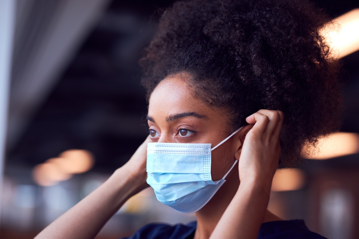 woman putting on mask