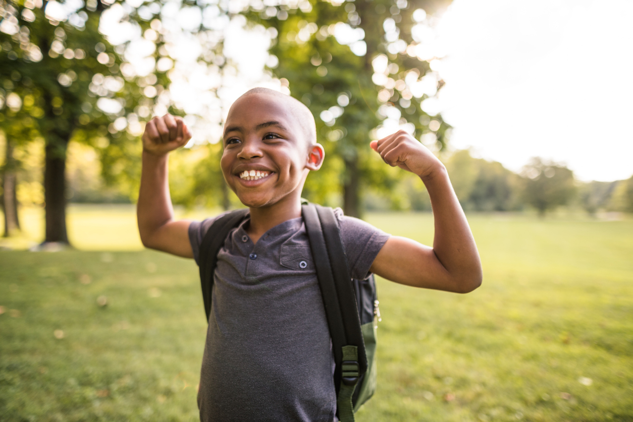 Child smiling and showing his muscles.