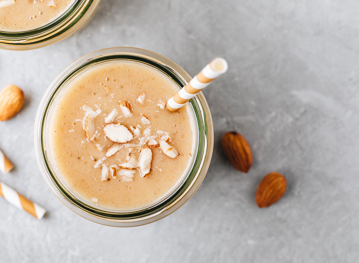 Protein shake with almonds and coconut shavings with a paper straw