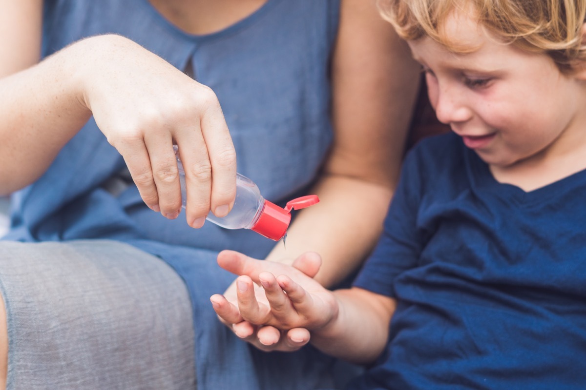 Mom pouring hand sanitizer in child's hand