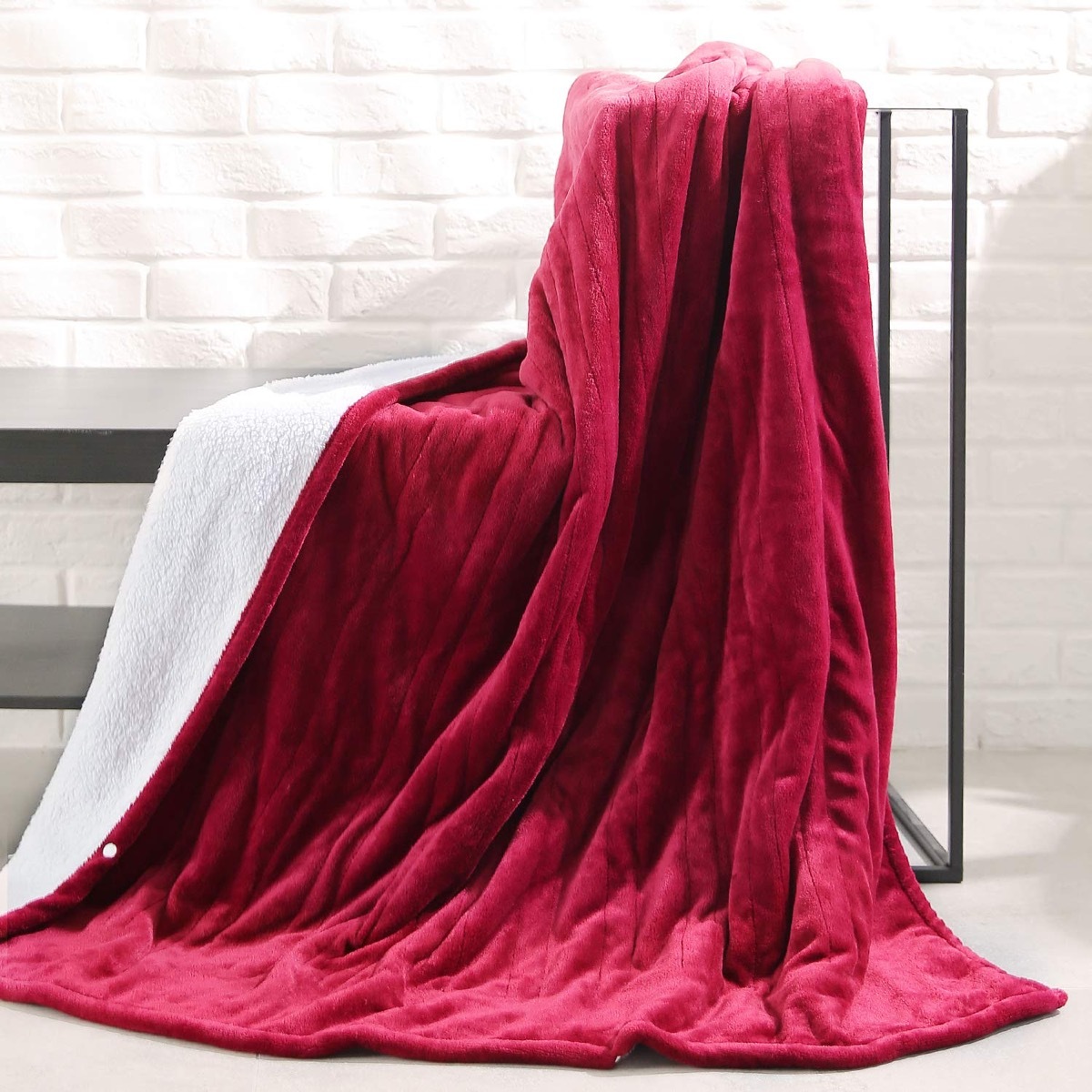 maroon blanket with white fleece lining draped over bench