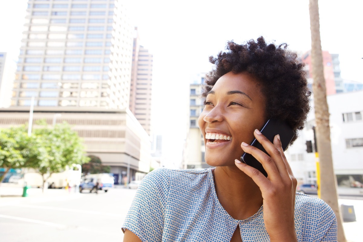 Black woman calling a friend on her cell phone