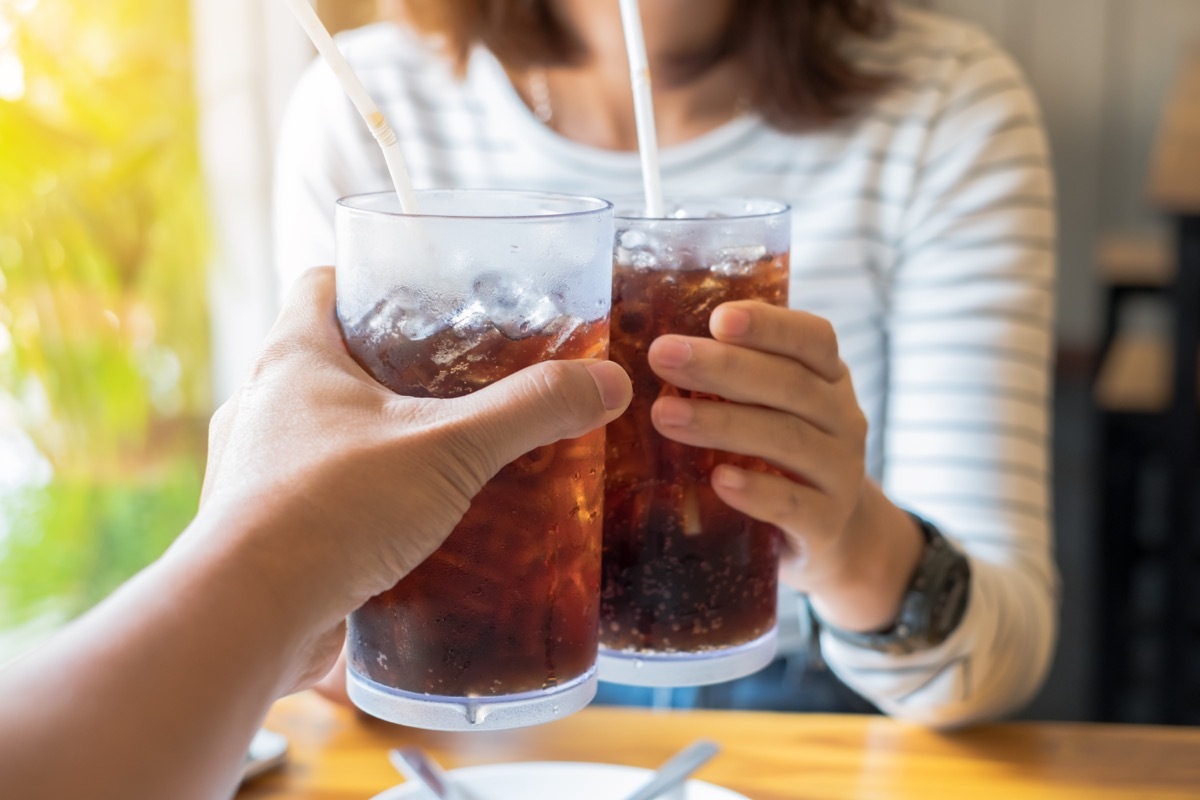 Men and Woman hand giving glass of cola.Glass of cola ,Soft drinks with ice, sweetheart or buddy