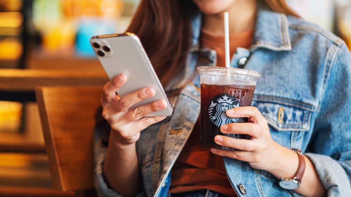 woman on phone drinking starbucks