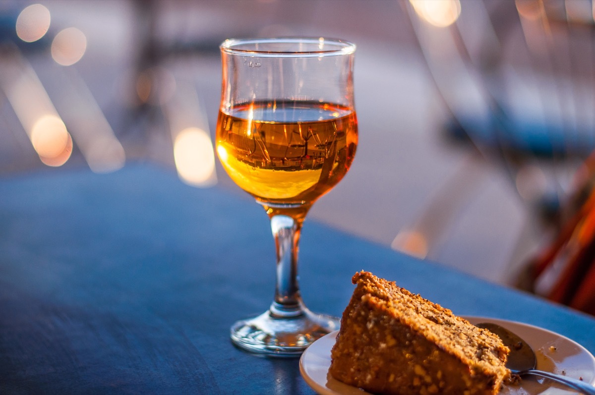 A glass of white dessert wine on a table in a cafe