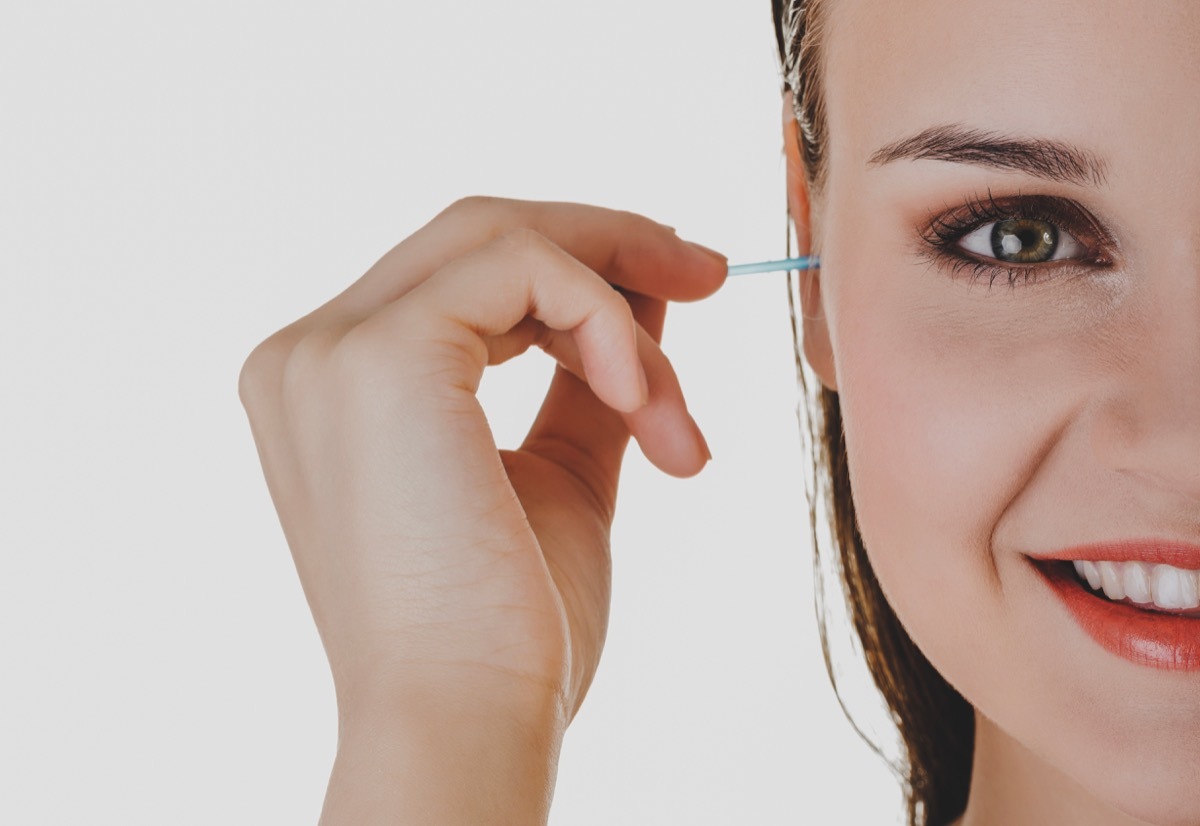 Woman putting cotton tips inside ear.