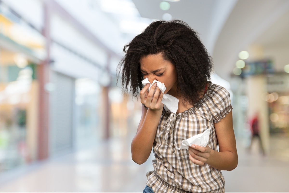 Woman blowing her nose after sneezing