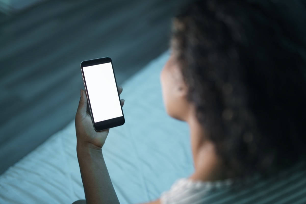 African american woman at home with smartphone