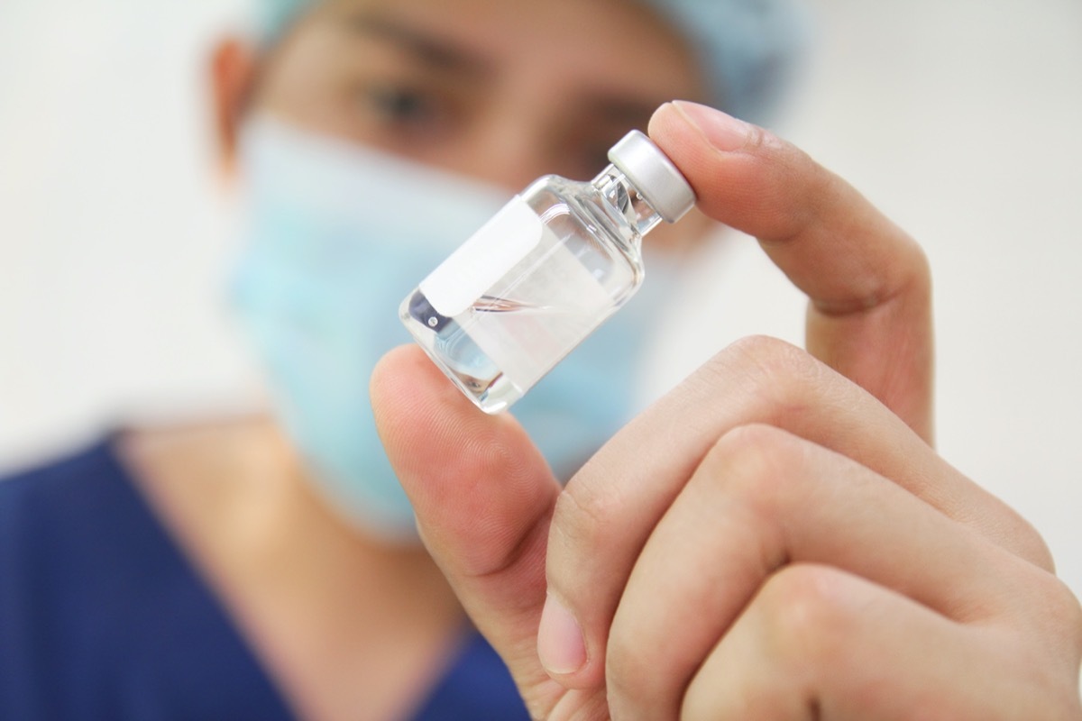 Nurse checking a vial of medicine.