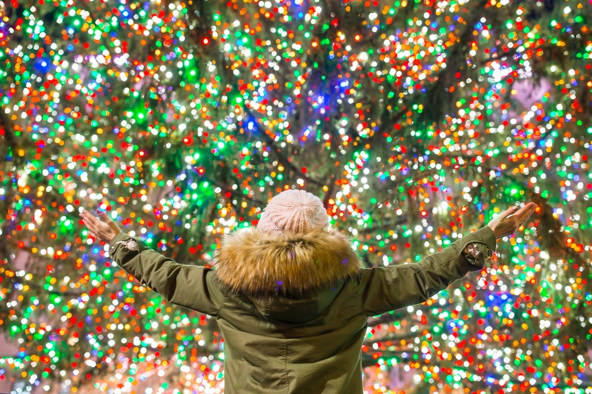 happy woman in front of rockefeller center tree