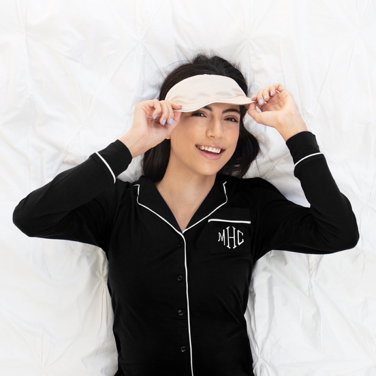 Woman wearing monogrammed pj's and sleep mask