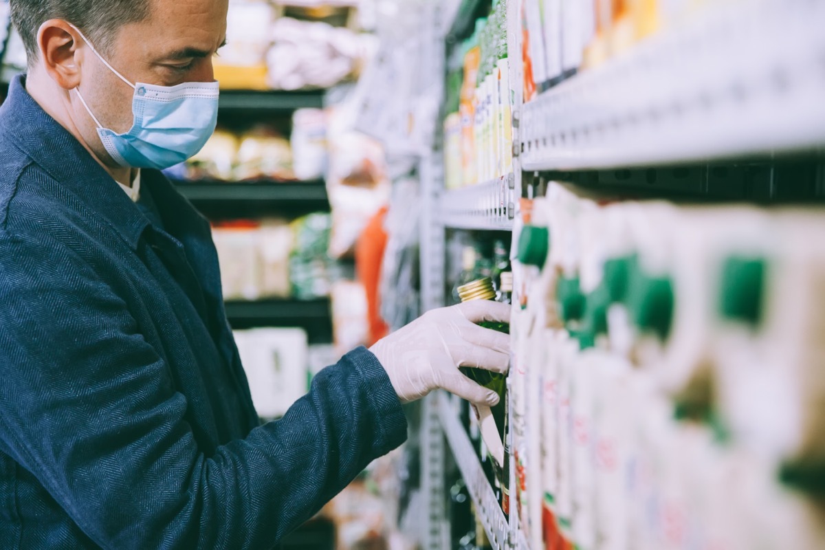 Man with face mask and rubber glove for protection shopping for groceries