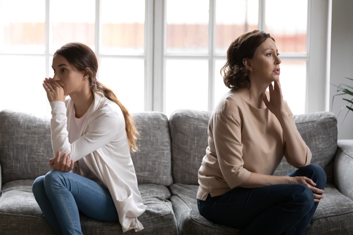 Two Women Sitting Back to Back on a Couch