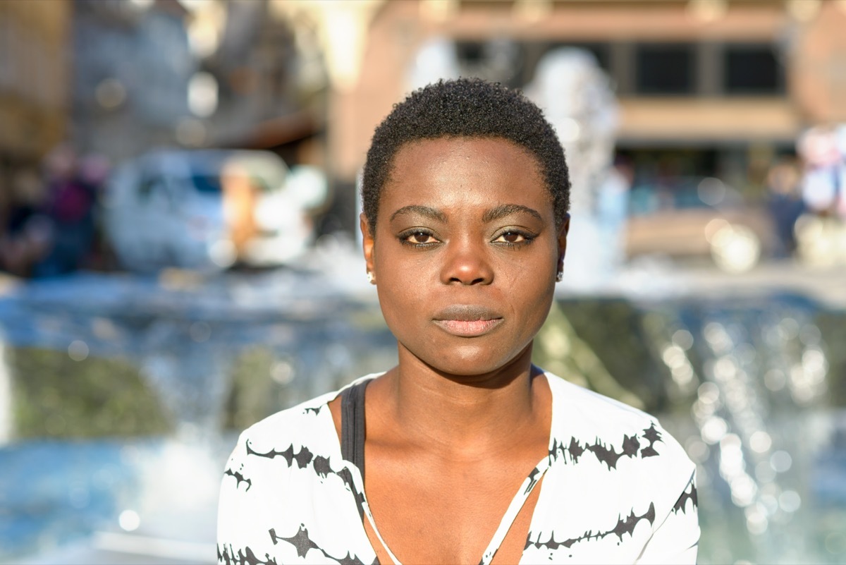 woman with a calm deadpan expression staring quietly at the camera