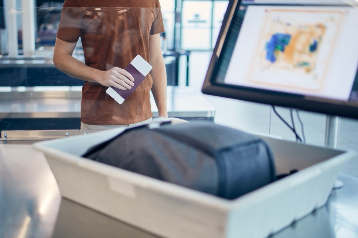 man taking bag through airport security