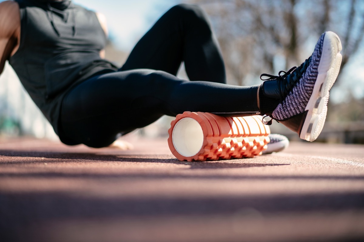 Man foam rolling. Athlete stretches using foam roller