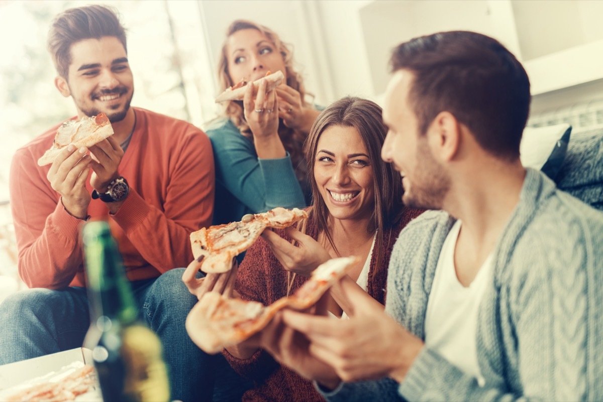 Friends Eating Pizza Together in living room