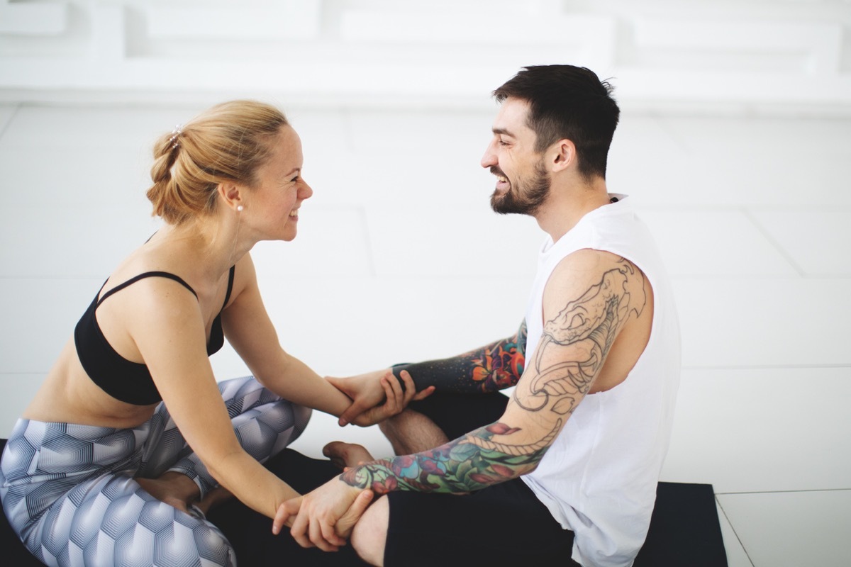 Young woman and man talking after yoga classes