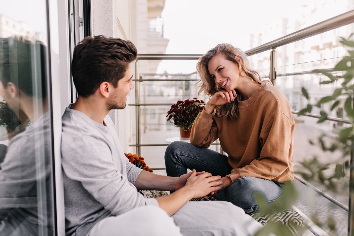 Young couple talking and holding hands on a terrace