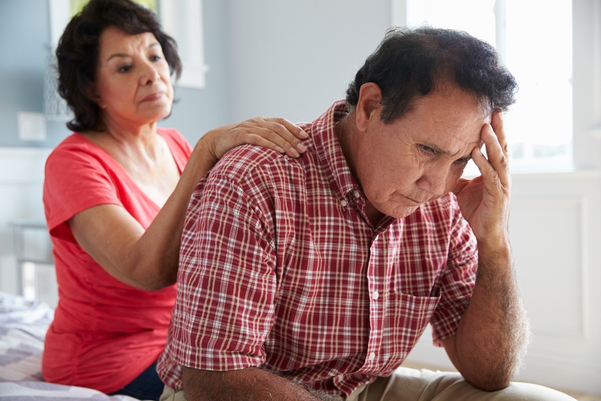 Wife Comforting Senior Husband Suffering With Dementia and looking confused