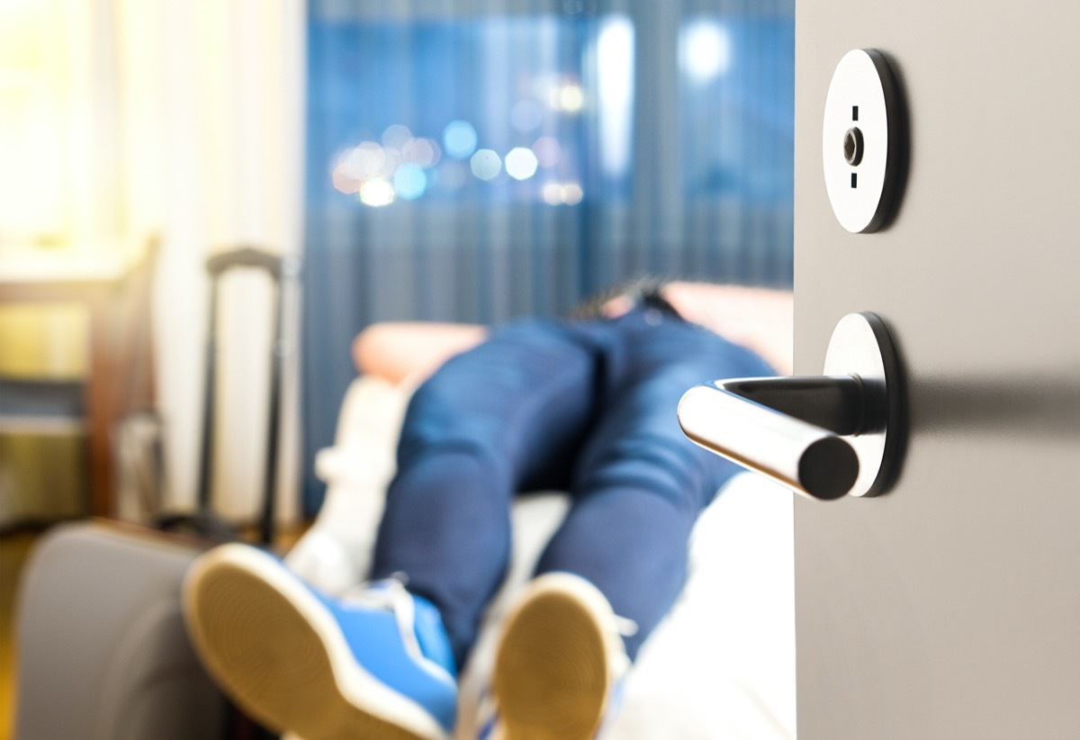 Tired traveler sleeping on hotel room bed