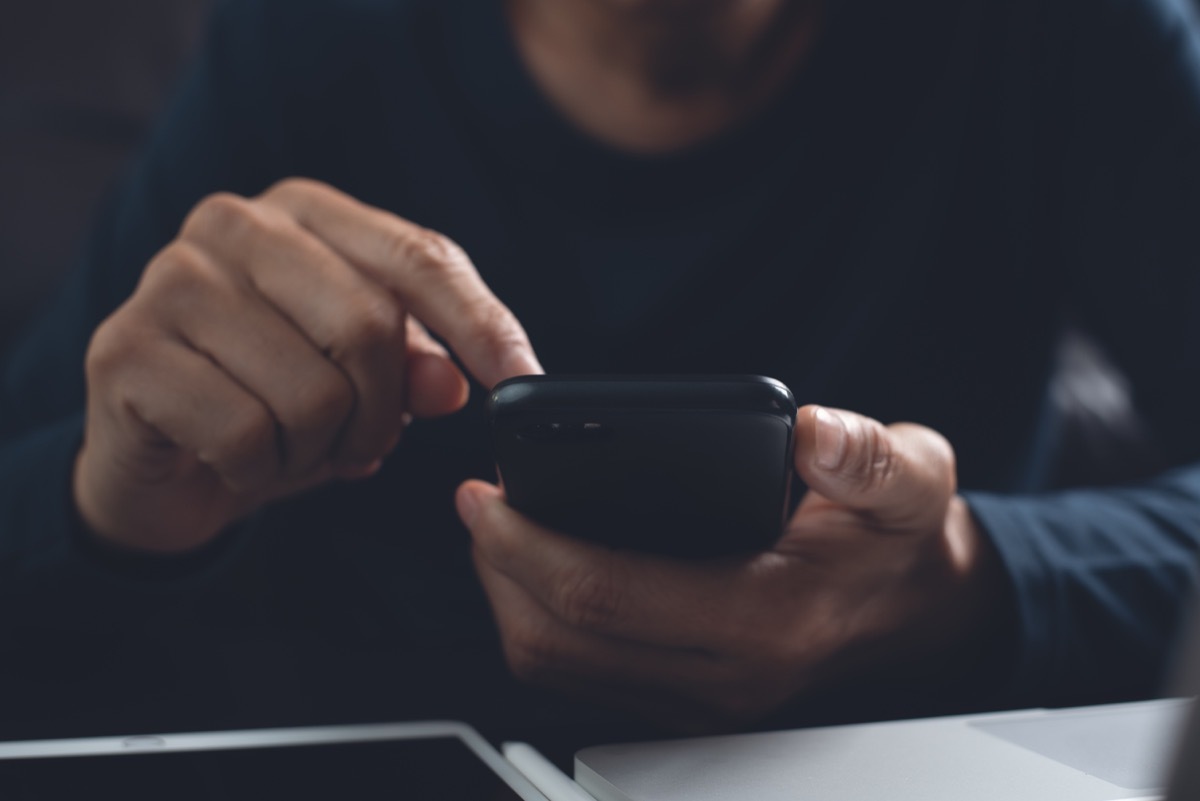 Closeup of man's hands scrolling through phone, 40 year old virgin