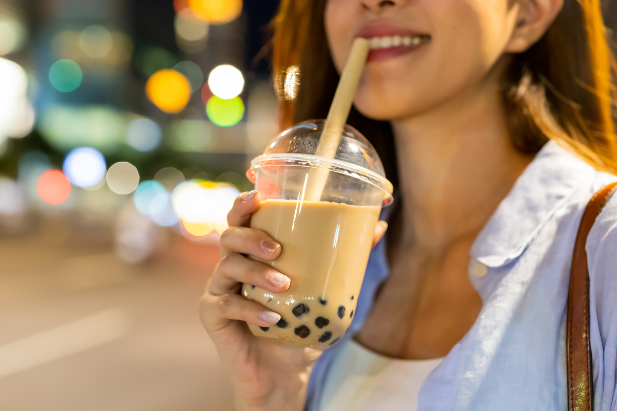 A young woman drinking bubble tea on a city street