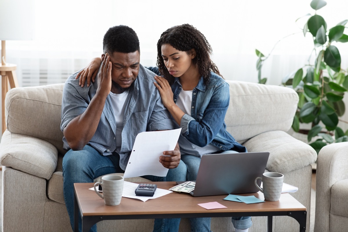 Family Financial Crisis Concept. Depressed Couple Looking At Invoice, Not Able To Pay Huge Bills