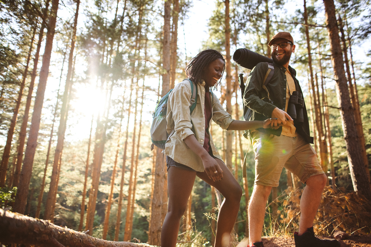 young couple laughing and hiking in the woods