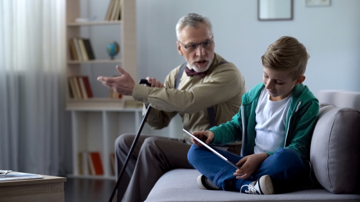 older man yelling at young boy playing on tablet, things that annoy grandparents