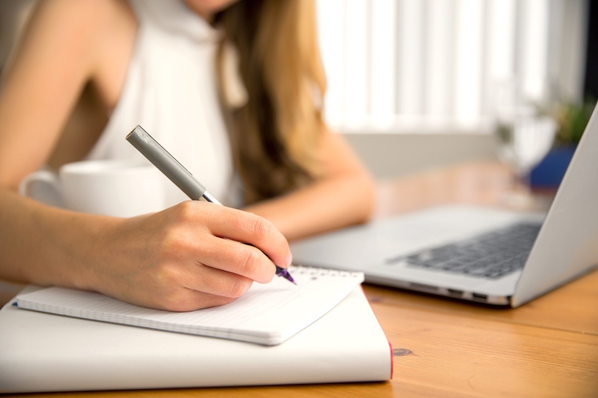 Woman Taking Notes in Planner