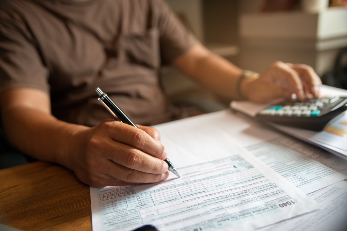 hand of Accountant calculate tax return and work at home