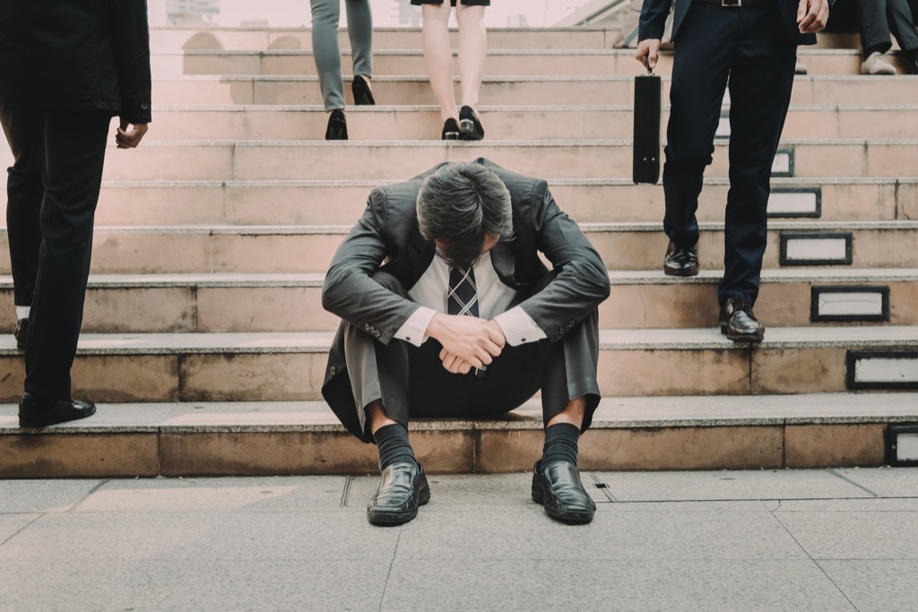 Businessman is a failure, sad on the steps