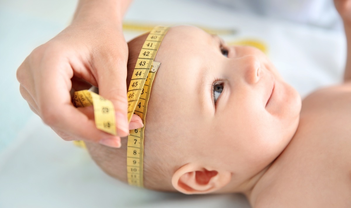 Professional pediatrician examining smiling baby