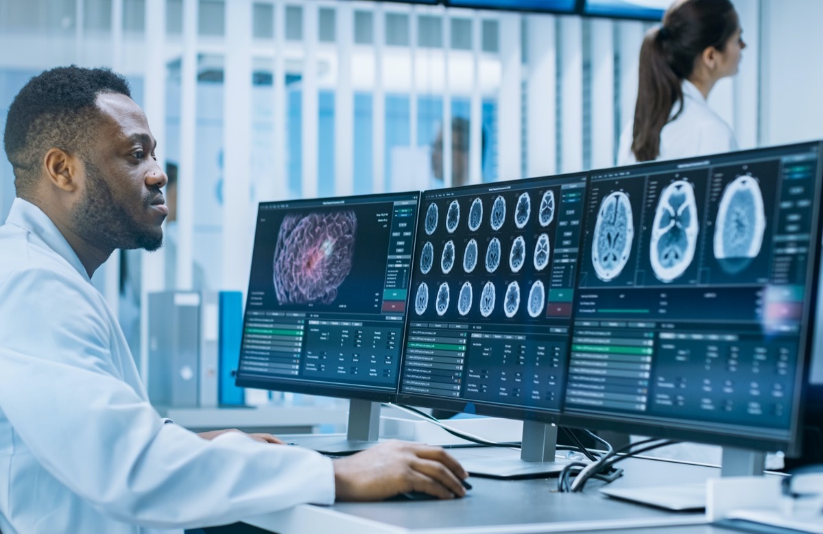 Medical Scientist Working with CT Brain Scan Images on a Personal Computer in Laboratory. Neurologists in Neurological Research Center Working on a Brain Tumor Cure