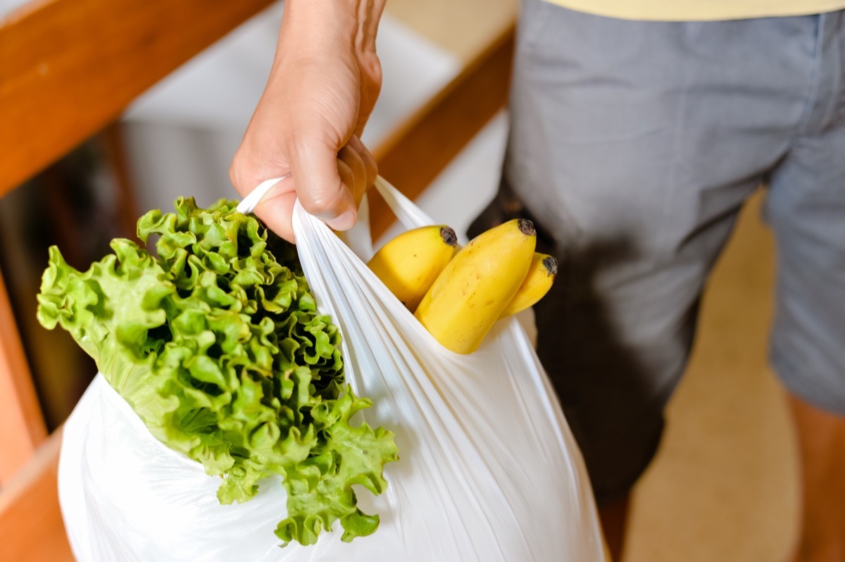 man carrying plastic bags with groceries