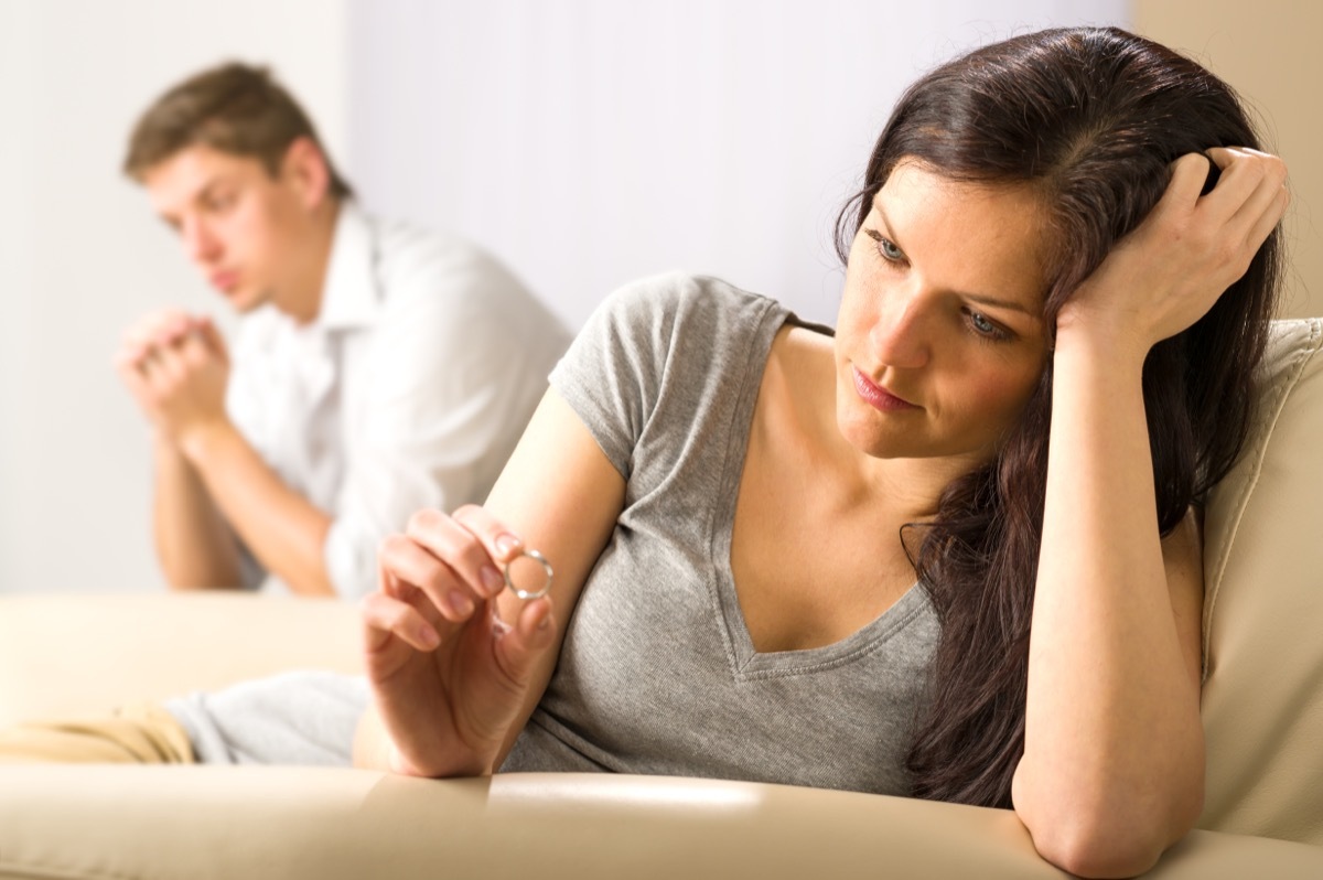 A sad looking couple sitting on a couch.