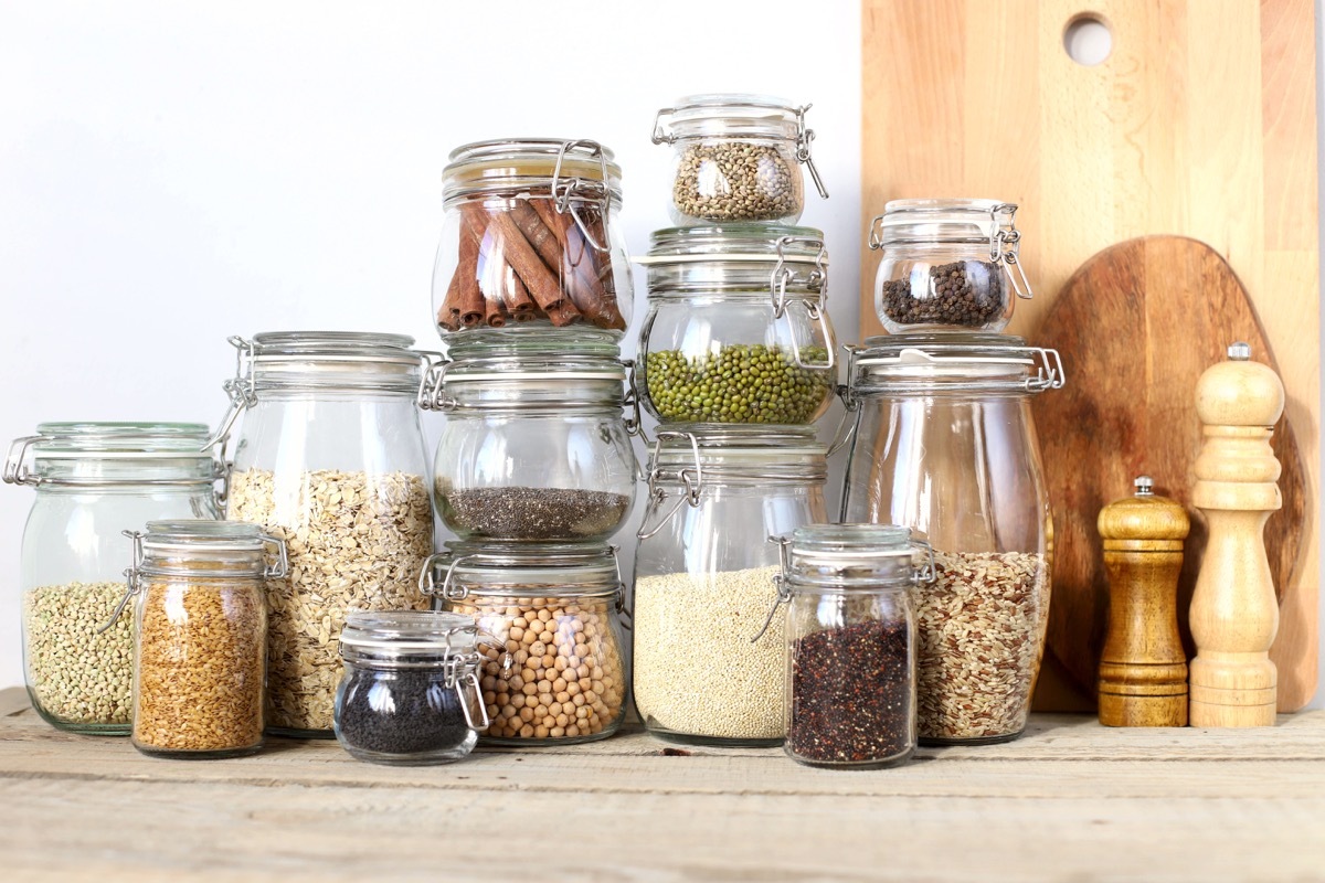 Healthy foods in glass jars. Cereals, seeds, legumes, spices. On a wooden table.