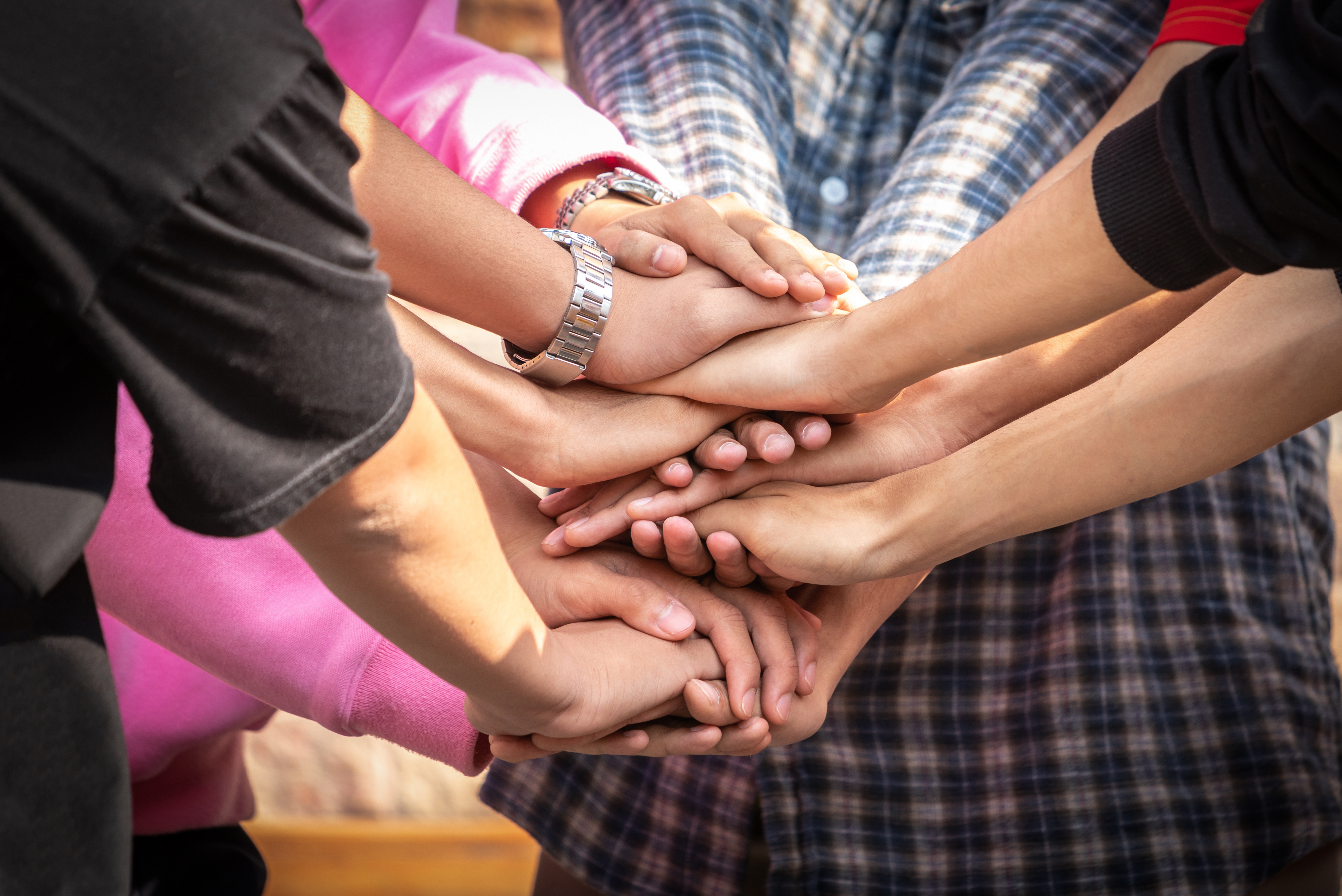 people stacking their hands in a display of teamwork