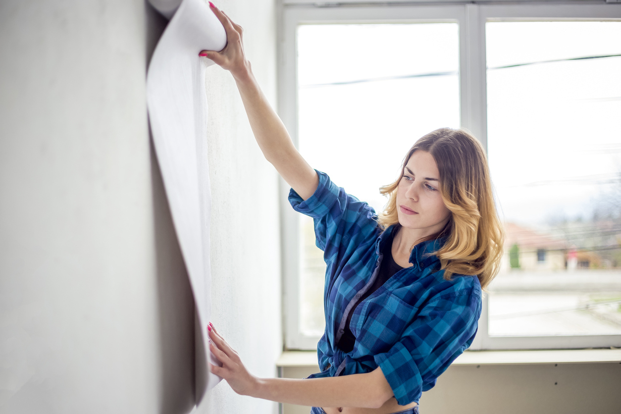 young woman choosing wallpaper design