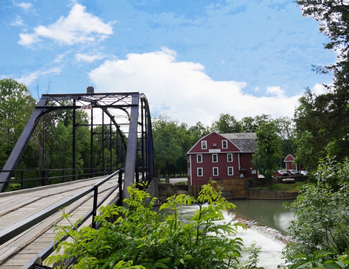 a photo of a red house and War Eagle bridge, which is nearby Cave Springs, Arkansas